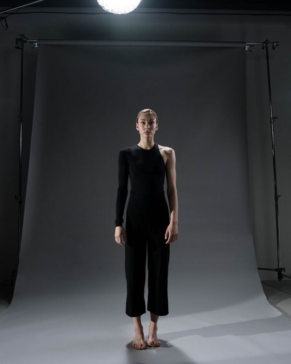 A person finding balance in a standing yoga pose in a minimalist room.
